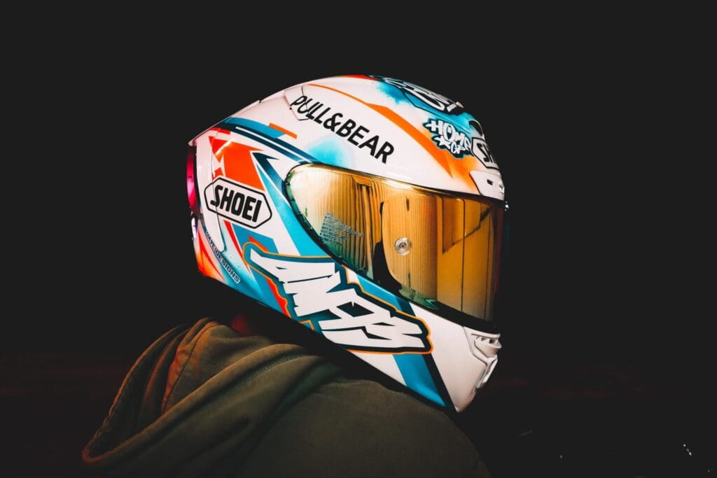 white, blue and orange motorcycle helmet with mirroed visor.