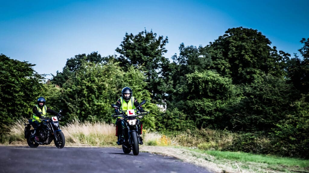 Motorcycle licence student learning to ride on the road as part of motorcycle training courses in the UK