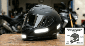 Black helmet with reflective stickers sitting on a wooden work bench